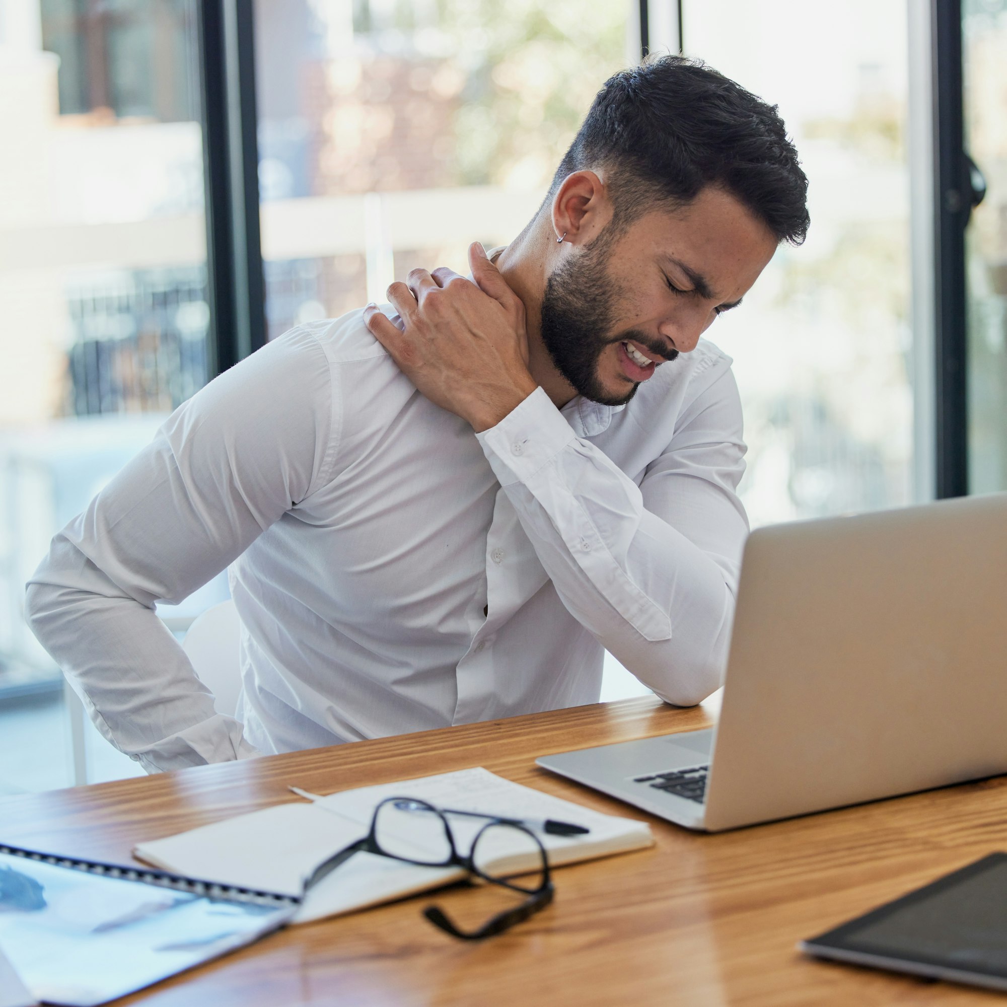 Man, shoulder pain and laptop while working in office suffering from stress, depression and burnout