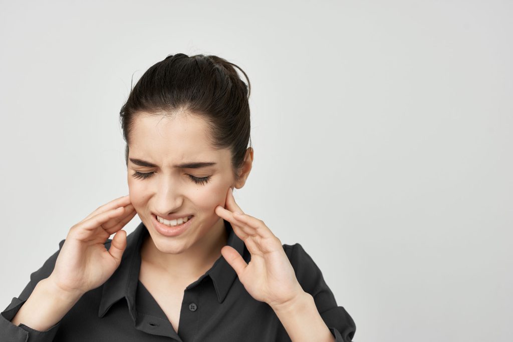 Woman holding her jaw.