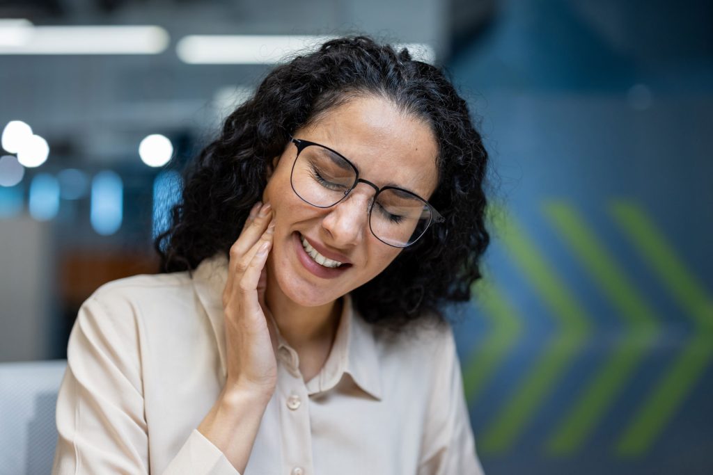 Woman with TMJ experiencing jaw pain.