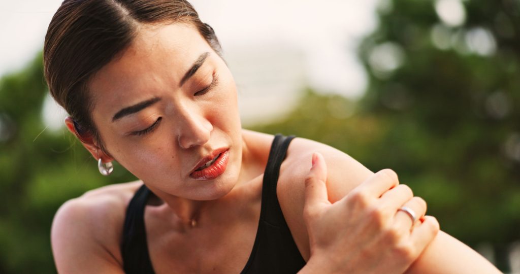 Fit woman suffering from shoulder joint pain.