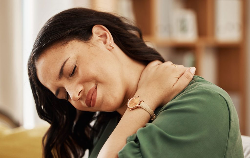 Woman holding her neck due to chronic pain.