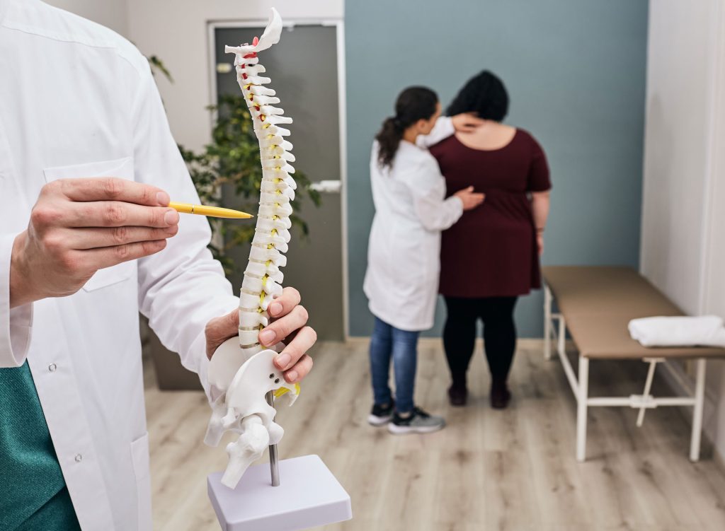 Doctor pointing to a spinal model.
